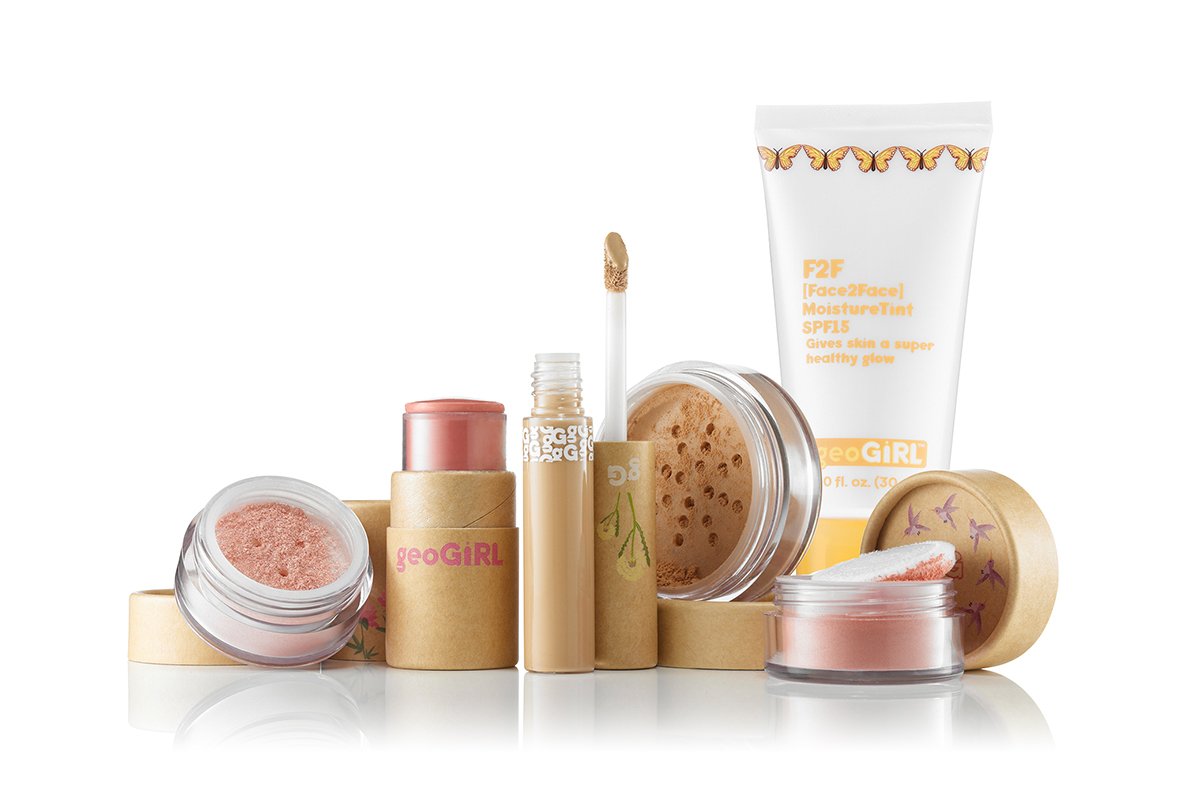 A collection of pink beauty products including jars, tubes, and containers from the brand geoGIRL, with some packaging labeled with the brand name and a tube labeled SPF 15 moisturizer tint.