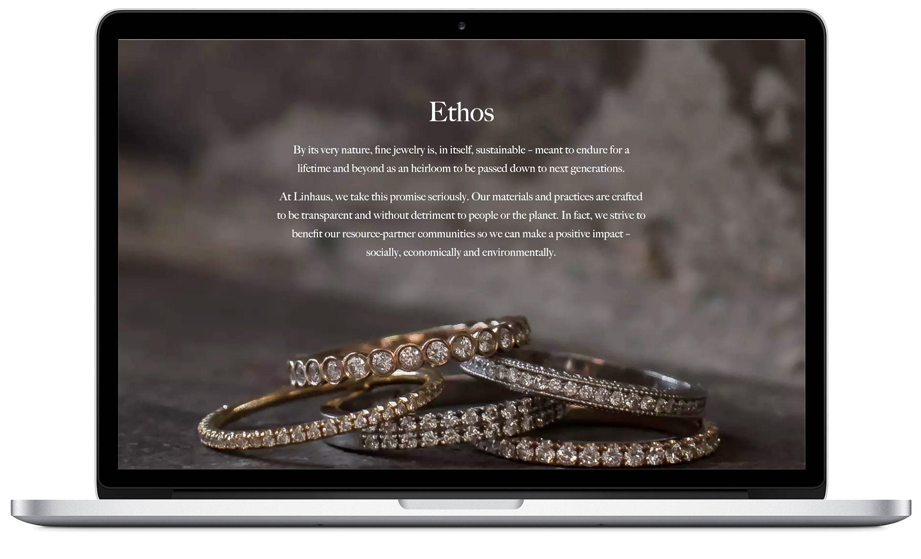 Laptop screen displaying a webpage about jewelry, featuring an image of diamond rings and a paragraph about ethics and sustainability.